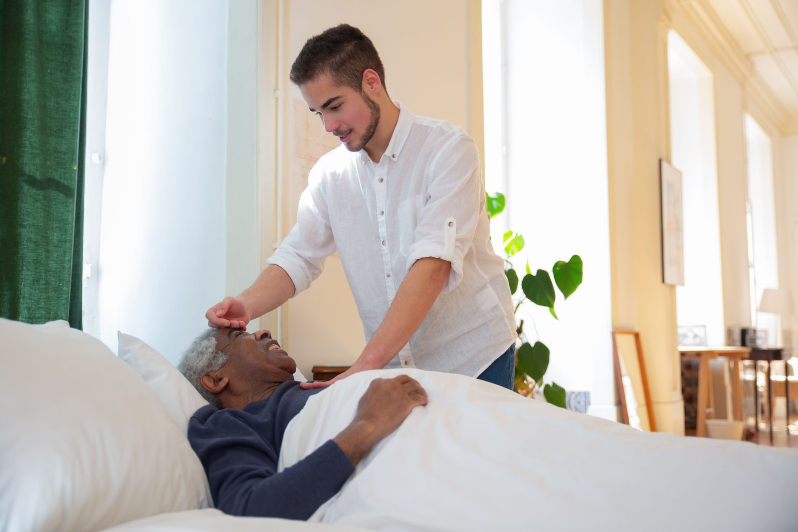 A FORYOH caregiver comforting a senior client resting in bed